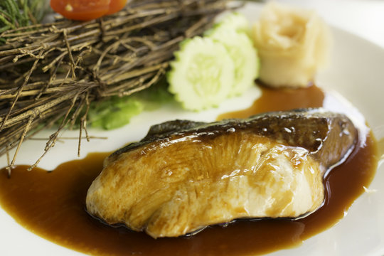 grilled sablefish with soy sauce on white plate
