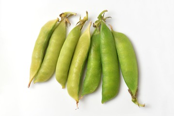 Bright and fresh peas on a white paper background
