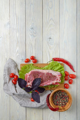 raw meat with ingredients on a wooden background