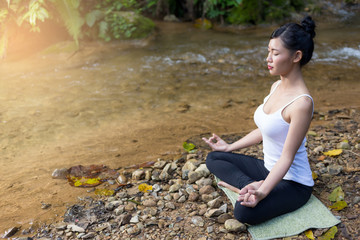 Young woman asia meditates while practicing yoga relax in nature