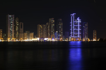 Fototapeta na wymiar Skyscrapers on the shores of Laguna Khalid. Night view. Sharjah. United Arab Emirates