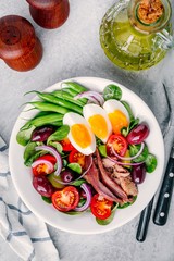 nicoise salad with tuna, anchovies, eggs, green beans, olives, tomatoes, red onions and salad leaves