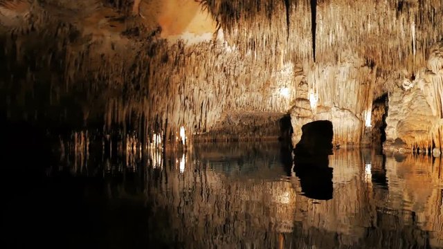MAJORCA, SPAIN Tourists float on a boat on the underground lake in the famous stalactite caves of Dragon (Cuevas del Drach)