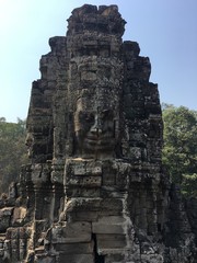 Angkor Wat in Siem Reap, Cambodia. Stone faces carved in the ancient ruins of Bayon Khmer Temple