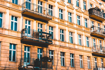 Fototapeta na wymiar orange residential facade with some ornaments and steel balcony