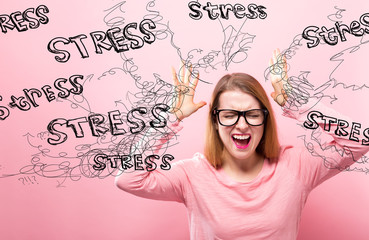 Stress with young woman feeling stressed on a pink background