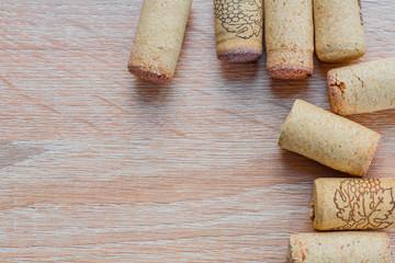 top view of used vine corks on wooden background with copy space