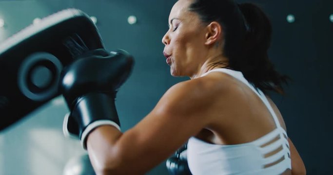 Beautiful athletic woman exercising boxing in the gym