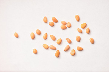 Useful pine nuts lie on a white paper background