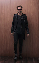 Fototapeta na wymiar a man is standing in a black leather jacket and jeans