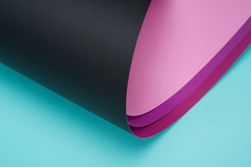 roll of black and pink paper on turquoise