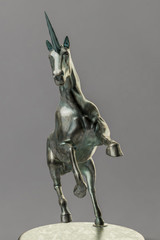 a beautyful bronze unicorn figure isolated on gray background © magann