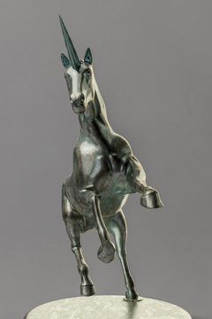 a beautyful bronze unicorn figure isolated on gray background