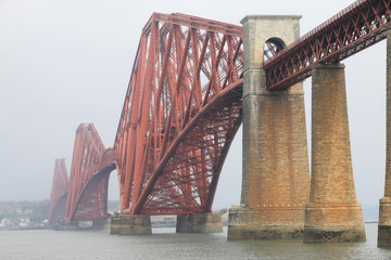 duży czerwony most o ciekawej knstrukcji na rzece we mgle