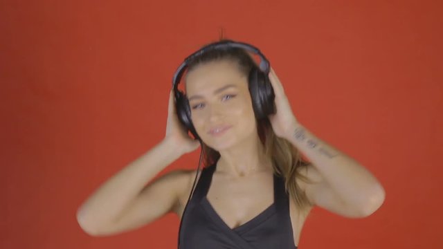 Sexy girl dancing to music with headphones. In RAW (low contrast) color format to preserve the maximum detail of the image.