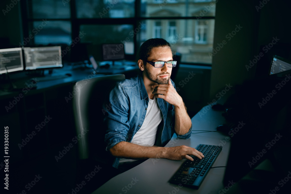 Wall mural programming. man working on computer in it office