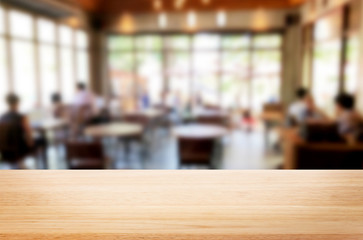 Selected focus empty brown wooden table and Coffee shop or restaurant blur background with bokeh image. for your photomontage or product display.