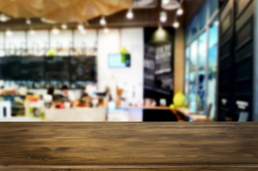 Selected focus empty brown wooden table and Coffee shop or restaurant blur background with bokeh image. for your photomontage or product display.