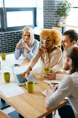 People Meeting  In Cafe Working On Notebook