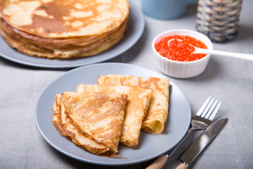 Traditional Russian pancakes with red caviar. Shrovetide. Maslenitsa week. Selective focus, close-up.