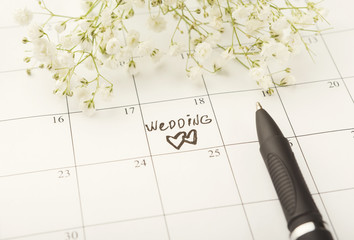 Word wedding on calendar with sweet flowers