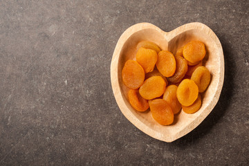 Dried apricot fruit in heart shaped bowl