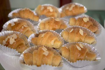 Close-up shot of a delicious almond croissant for a coffee break.