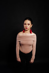 Studio portrait of brunette girl with make up on black background.