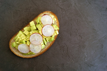 Delicious healthy sandwich with avocado on a gray background.
