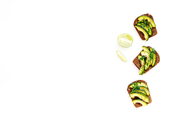 Snacks with avocado. Avocado toast with rye bread on white background top view copy space