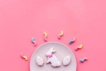 Easter gingerbread and cookies. Easter eggs and Easter bunny concept. Pink background top view copy space