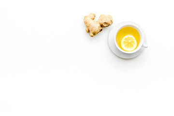 Cup of ginger tea near ginger root on white background top view copy space