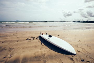 White Surfboard with leg leash on beach