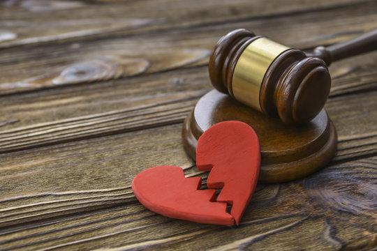 figure of a broken red heart, gavel, hammer of a judge on a wooden background. Divorce proceedings, the dissolution of marriage. court, law.