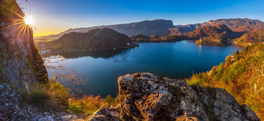 Bled, Slovenia - Beautiful autumn sunrise at Lake Bled on a panoramic shot with Pilgrimage Church of the Assumption of Maria and Alps at the background with clear blue sky