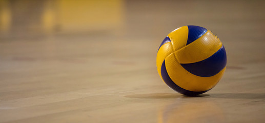 Volleyball ball on blurred wooden parquet background. Banner, space for text, close up view with...