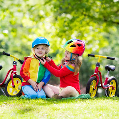 Kids ride balance bike in park