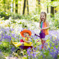Kids with bluebell flowers, garden tools