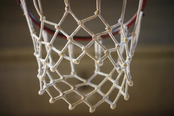 Fototapeta na wymiar Basketball hoop with white net. Blurred background, close up view with details.