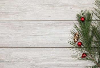 Red and Golden Pinecone ornaments laying on white wooden backdrop