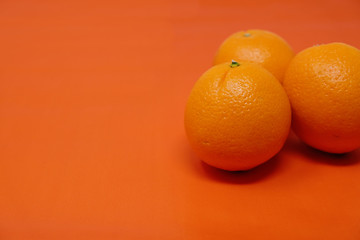 Orange fruit staged with simple color background.  Shows trio of the fresh citrus fruit for organic produce within the food industry.