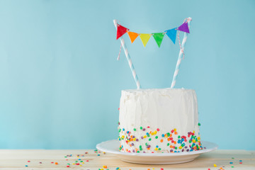 Birthday background - striped rainbow cake with white frosting