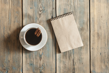 top view of espresso coffee cup and blank note book on wooden table