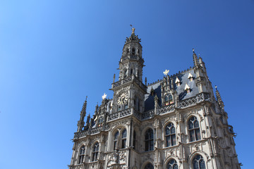 Fototapeta premium The beautiful 14th century, late gothic style Oudenaarde Town Hall, in East Flanders in Belgium. Against a background of blue sky with copy space.