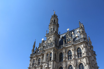 Fototapeta na wymiar The beautiful 14th century, late gothic style Oudenaarde Town Hall, in East Flanders in Belgium. Against a background of blue sky with copy space.