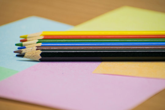 Close up stack colour pencils on papper and wooden background