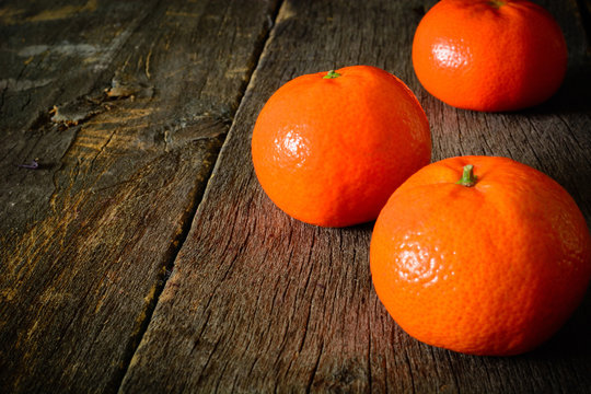 A few mandarins on a wooden background. The cleared fruit.