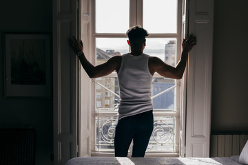Man opening shutters at home