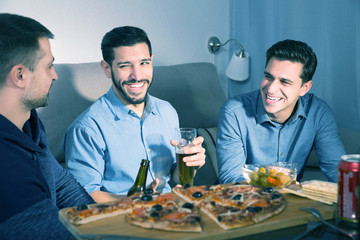 Three men talking and laughing at home