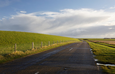 Fototapeta na wymiar road between green hills and blue sky